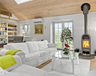 Stue med brændeovn og hvid sofa